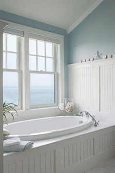 a large white bath tub sitting next to a window