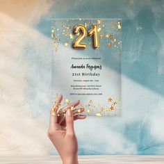 a hand holding up a 21st birthday card with gold stars on it and the number twenty