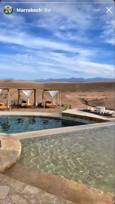 an outdoor swimming pool surrounded by lounge chairs