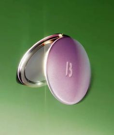 a purple pill with the letter b on it sitting in front of a green background