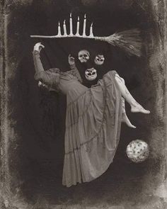 an old black and white photo of a woman with candles on her head holding a broom