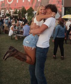 two people hugging each other in front of a crowd at a music festival with the word poin written on it