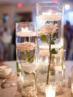 candles and flowers in glass vases on a table