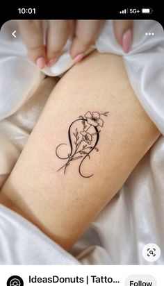 a woman's thigh with flowers on it and the word love written in cursive