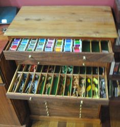 a wooden desk with drawers filled with different colored pencils and pens on top of it