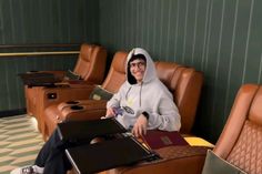 a man sitting in a chair with two laptops