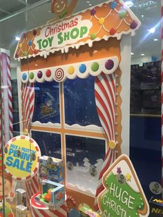 a christmas toy shop display with candy and candies in the window, including an ice cream stand