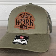 I Don't Know I Just Work Here Funny Leather Patch Hat Green/Camo. Specifications: 🧢 Richardson original 112 trucker; adjustable for the perfect fit 🎩 60/40 cotton/polyester blend for comfort 📏 One size fits most 🏷️ Expertly laser engraved leatherette patch design 📦 Ships in 2 to 3 business days from our Orlando Studio Care Instructions: 🚫 Do not wash; spot clean only Please Note: 🌈 Colors may vary from photos based on your viewing screen. This funny hat is a unique and entertaining gift for fathers, embracing their dual role with humor. Casual Baseball Cap For Outdoor Work, Adjustable Baseball Cap For Outdoor Work, Khaki Trucker Hat For Outdoor, Khaki Trucker Baseball Cap For Outdoor, Outdoor Fitted Trucker Hat With Curved Bill, Khaki Trucker Snapback Hat For Outdoor, Khaki Flat Brim Trucker Hat For Outdoor, Adjustable Snapback Hat For Outdoor Work, Adjustable Khaki Trucker Hat