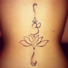 the back of a woman's neck with a lotus tattoo on her lower back