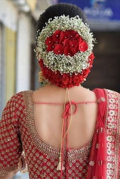 the back of a woman's head is adorned with flowers and baby's breath