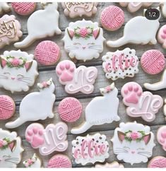 decorated cookies with pink and white icing on a wooden surface, including one that says hello kitty