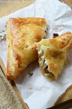 two pastries sitting on top of a piece of wax paper