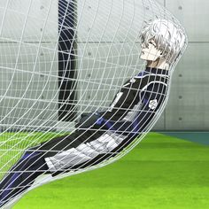 an anime character sitting in front of a soccer goal with his feet on the ground