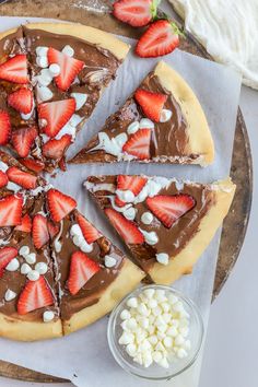 a chocolate pizza topped with sliced strawberries and marshmallows