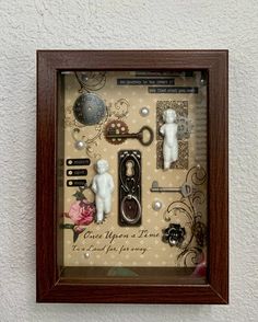 there is a shadow box with some things in it that look like keys and scissors