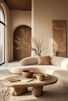 a living room filled with furniture next to a tall window and a tree in the corner