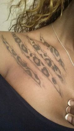 a woman's chest with an animal print tattoo on her upper arm and shoulder