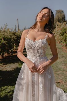 a woman in a wedding dress posing for the camera with her hands on her hips