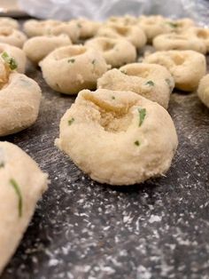 several doughnuts are being made and placed on a baking sheet with green sprinkles