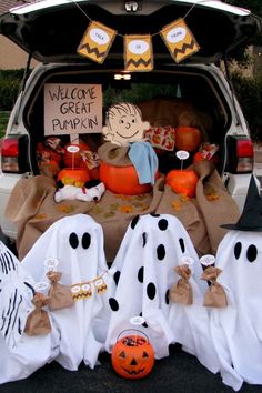 halloween decorations in the trunk of a car with pumpkins and ghost bags on it