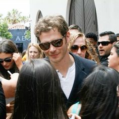 a man in sunglasses is surrounded by people