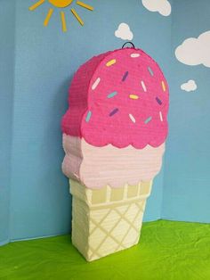 an ice cream cone with sprinkles on it sitting in front of a blue wall