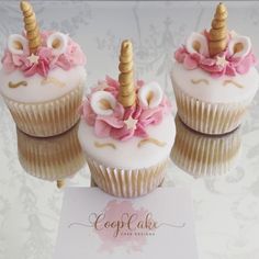 three cupcakes decorated with pink and gold icing