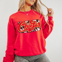 You are going to love this super cute and cozy Kansas City Chiefs Sweatshirt! This is a unisex fit sweatshirt, made with direct to film transfer, no vinyl or sublimation is used.  In order to provide the most color choices, sweatshirts in Pepper, Grey, and Ivory are made using Comfort Colors 100% soft ring-spun cotton, while sweatshirts in white, black, red, and sand are made using Gildan Cozy Feel, 50% cotton 50% poly blend. Both have a ribbed collar and relaxed fit and will make a great addition to your game day wardrobe.  T-shirts are comfort colors soft washed garment-dyed tees, renowned for their softness, comfort, and durability. Made with 100% ring-spun cotton, and sure to make an excellent choice for comfortable daily wear. T-shirts have double needle stitching throughout, sewn in Retro Graphic Print Sweatshirt For Game Day, Trendy Game Day Crew Neck Sweatshirt, Pop Culture Sweatshirt With Letter Print For Fans, Trendy Crew Neck Sweatshirt For Game Day, Pop Culture Letter Print Sweatshirt For Fans, Pop Culture Letter Print Sweatshirt Fan Merchandise, Cotton Graphic Print Sweatshirt For Fan Merchandise, Pop Culture Cotton Sweatshirt For Fall, Cotton Graphic Print Sweatshirt For Fans