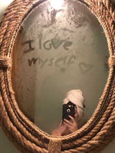 a person taking a selfie in front of a rope mirror