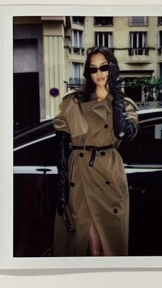 a woman in a trench coat and black gloves