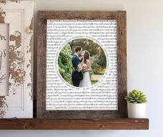 a wooden shelf with a framed photo on it next to a potted succulent