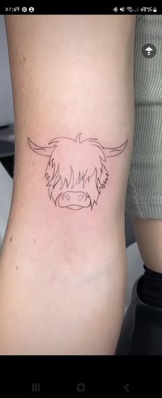 a woman's leg with a small tattoo of a cow on the lower thigh