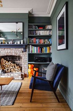 a living room filled with furniture and a fire place in front of a book shelf