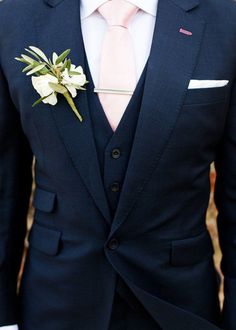 a man in a suit and tie with a boutonniere on his lapel