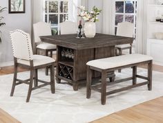 a dining room table with four chairs and a wine rack