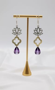 The Filigree Dangling Purple Stone Earrings are adorned with faceted fancy-cut cubic zirconia stones, elegantly set in intricate filigree designs. These stunning earrings offer a touch of vintage charm and vibrant color, perfect for adding a statement to any ensemble. Length: 2.30” Width: 0.78” Closure: Fish Hook Material: Brass with 18K Gold Plating with Rhodium Coating Lead Free and Hypoallergenic Purple Stone Earrings, Purple Earrings, Filigree Design, Purple Stones, Stunning Earrings, Unique Earrings, Fish Hook, Stone Earrings, Vintage Charms