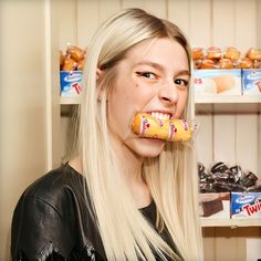 a woman with long blonde hair eating a bagel