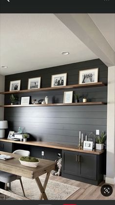 a living room filled with furniture next to a wooden table and shelves on the wall