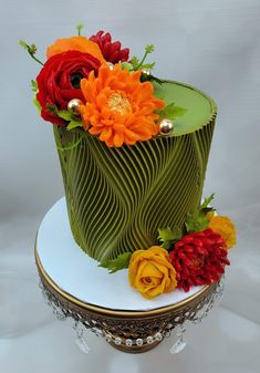 there is a green cake with flowers on it