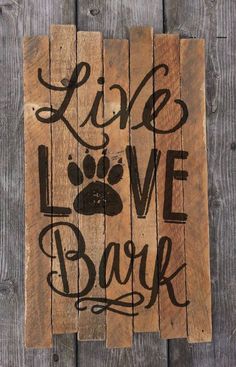 a wooden sign that says live love bark with a dog's paw on it