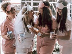 three women dressed in pink and white are talking to each other while one holds a can