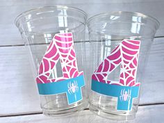 two plastic cups with spider - man stickers on the side, one is pink and blue