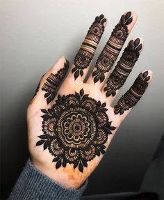 the hand is decorated with black henna