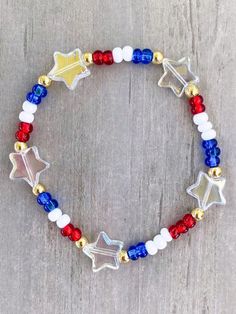 the patriotic bracelet with stars and beads is shown on a wooden surface, ready to be worn