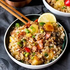 two bowls filled with rice and vegetables next to chopsticks