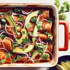 a casserole dish with chicken, onions, avocado and cilantro