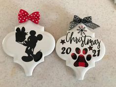 two christmas ornament shaped like mickey and minnie mouses with bows on them