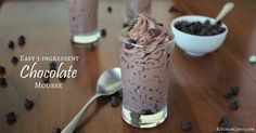 chocolate mousse in a glass with spoons and bowl of chocolate chips next to it