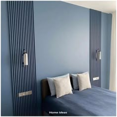 a bed sitting in a bedroom next to a blue wall with vertical stripes on it