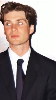 a man in a suit and tie looking at the camera with an intense look on his face